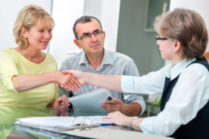 Couple Shaking Hands With Woman